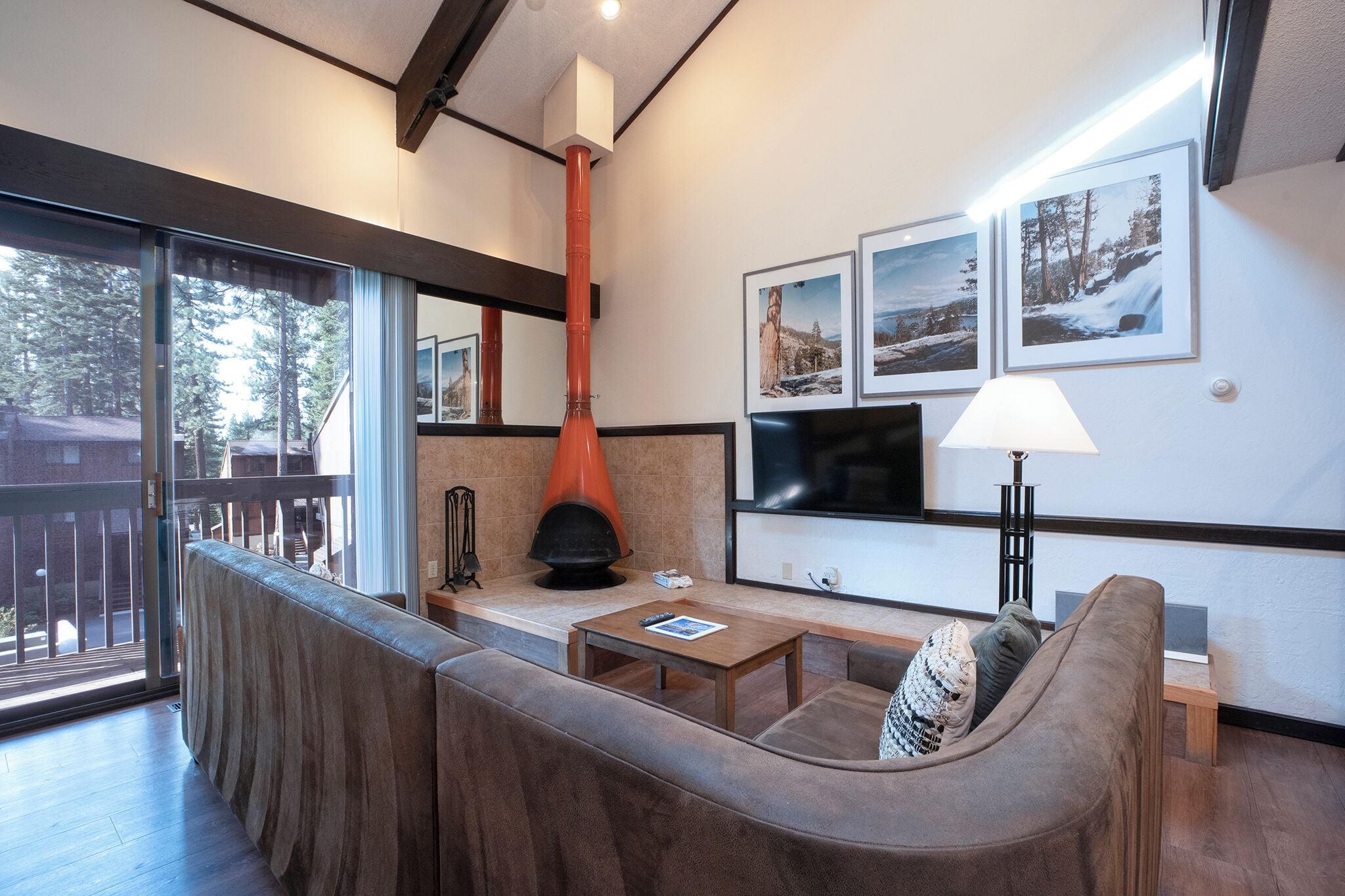 Uma sala de estar moderna com lareira, um sofá, uma mesa de centro e uma TV fixada na parede.