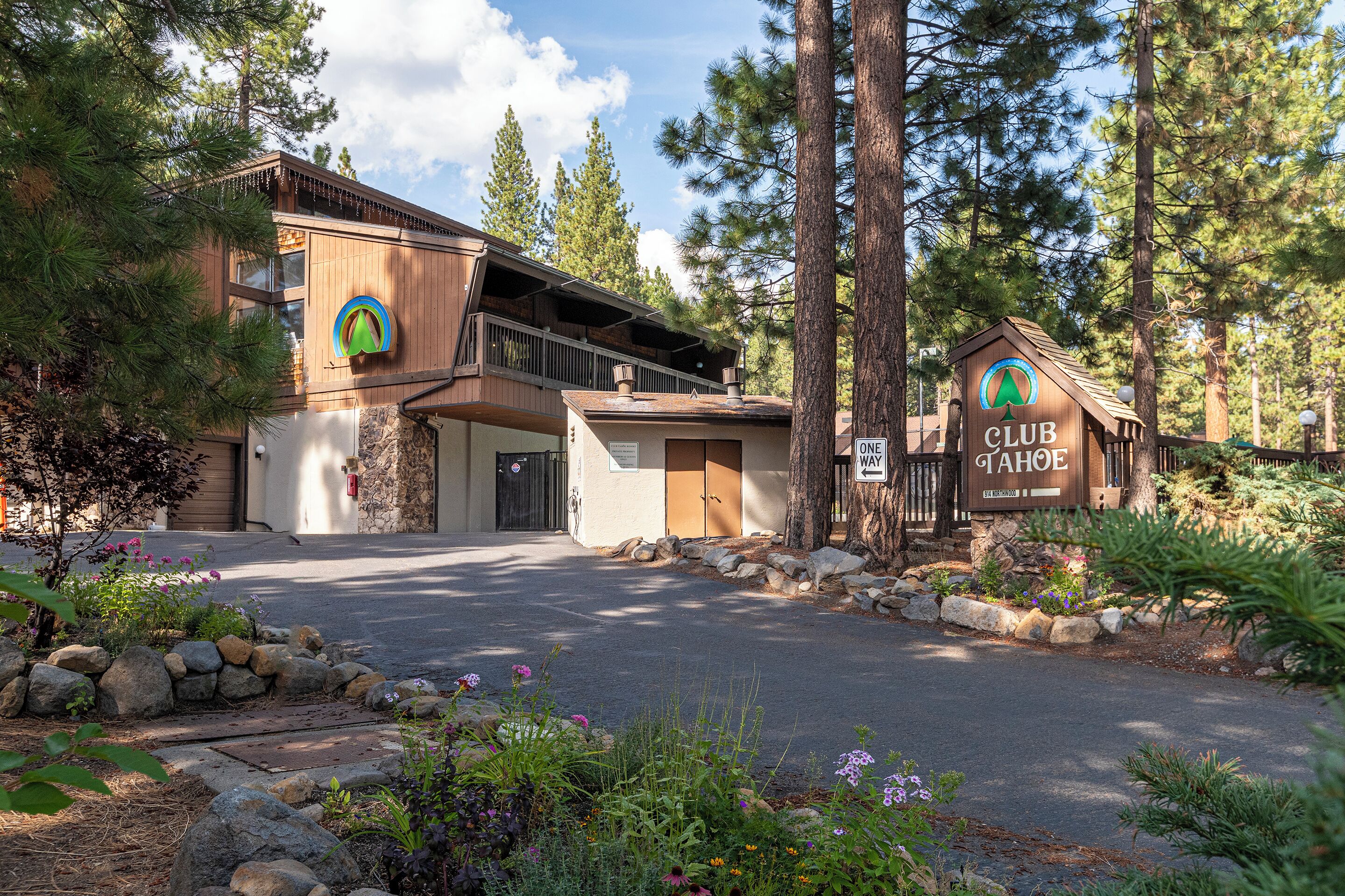 A lodge with a wooden exterior, a balcony, and a sign indicating it's a club.