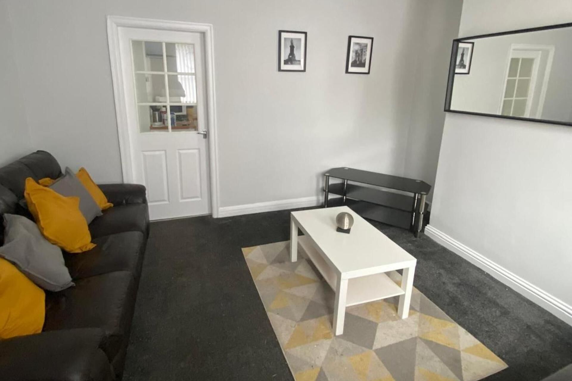 A modern living room with a white sofa, a coffee table, and a bench.
