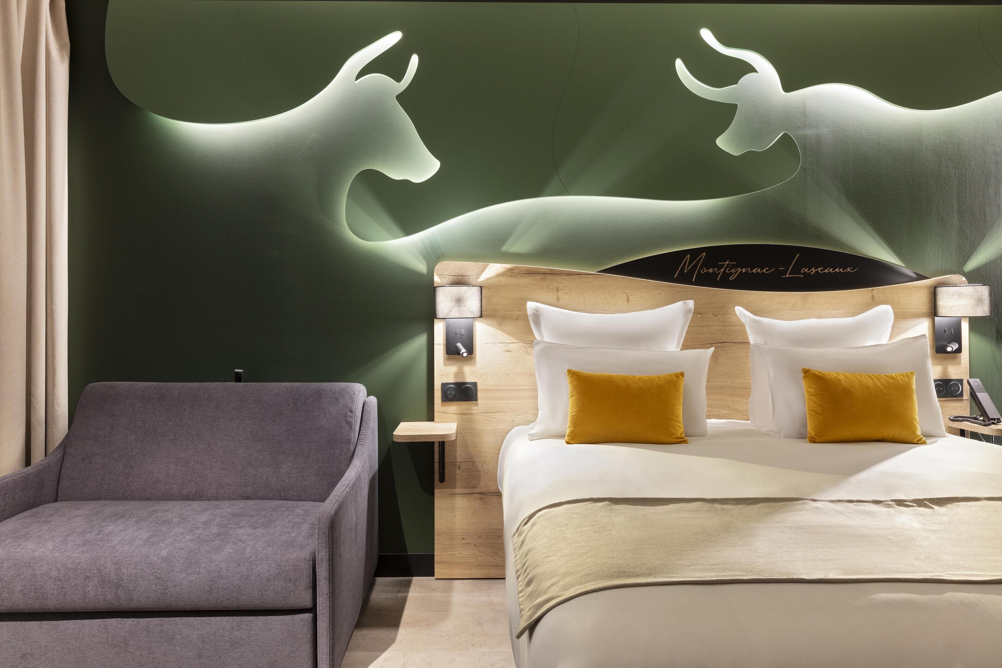 A modern hotel room with a bed, a nightstand, a lamp, and a chair.