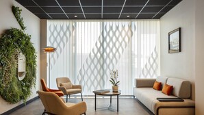 A modern living room with a sofa, two armchairs, a coffee table, and a decorative plant wall. - Hôtel Ostoria Périgueux, BW Signature Collection (Marsac-sur-l'Isle)