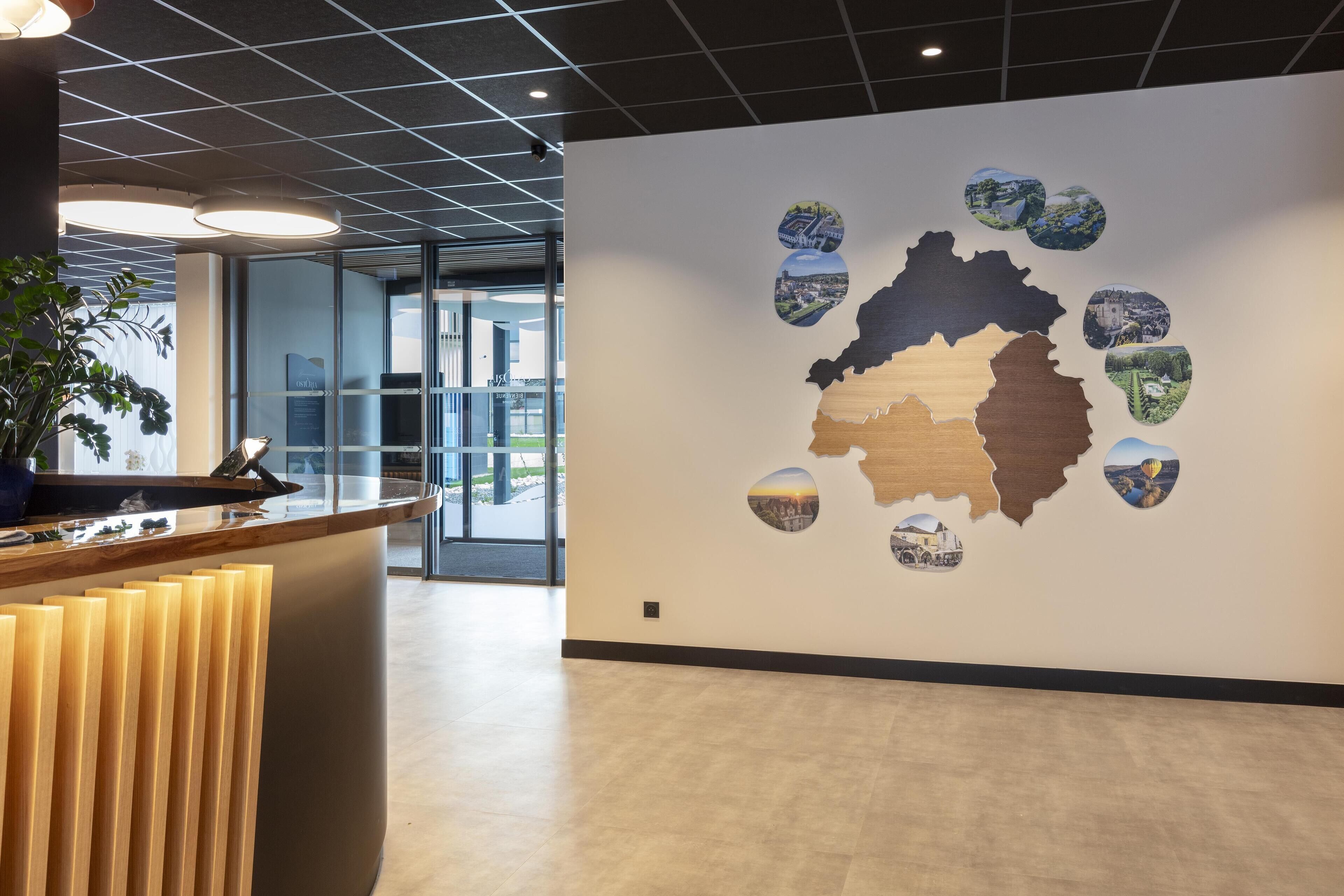 A reception area with a modern design, featuring a wooden reception desk, a large wall map, and a glass door leading to the outside.