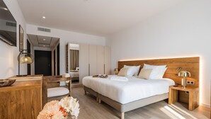 A modern hotel room with a large bed, wooden headboard, bedside tables, a desk, and a mirror. - Best Western Premier A Storia Solenzara (Sari-Solenzara)