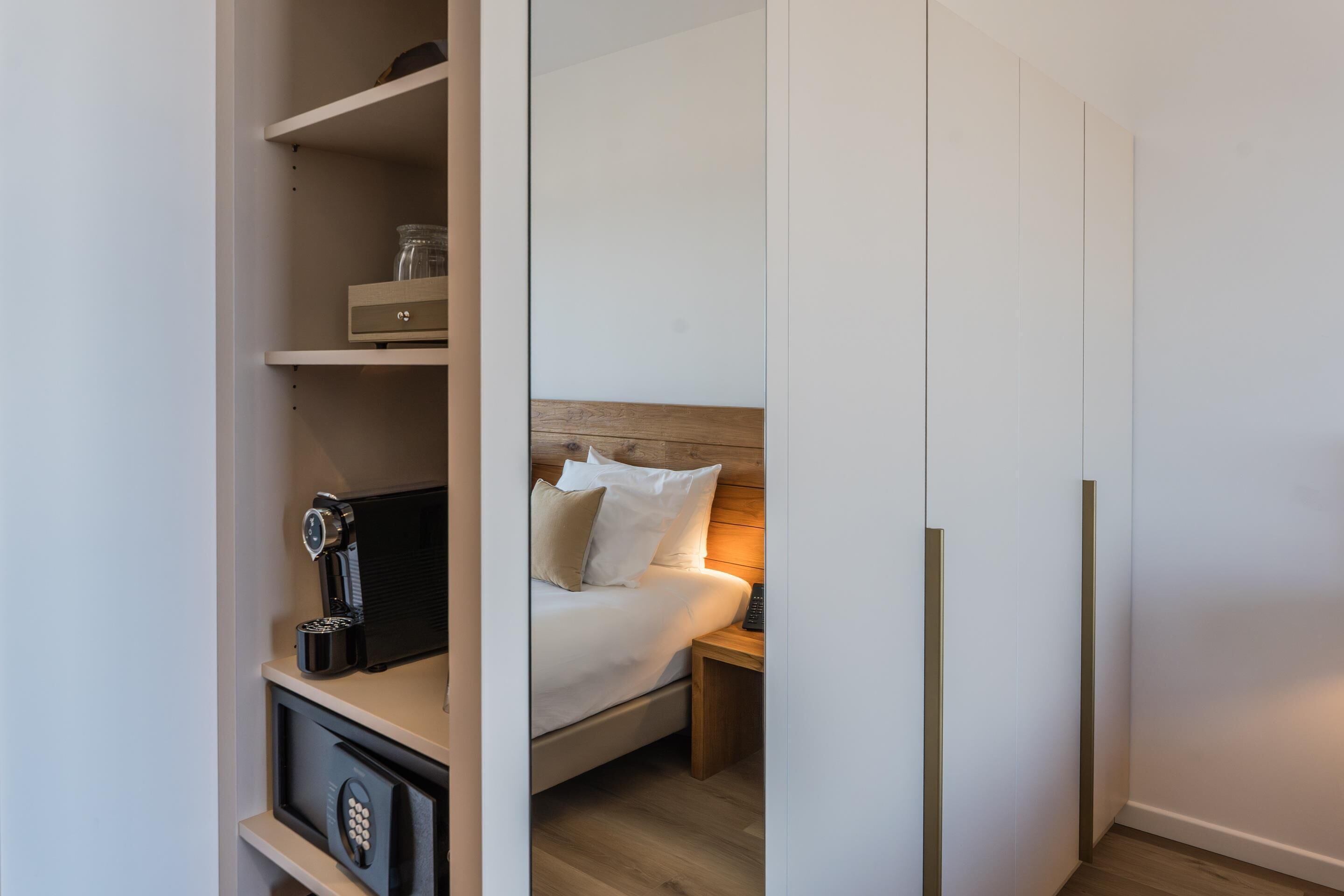 A bedroom with a bed, nightstand, and a built-in wardrobe.