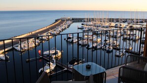 A marina with boats docked, a table and chairs, and a view of the sea. - Best Western Premier A Storia Solenzara (Sari-Solenzara)