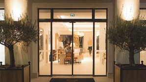 A hotel entrance with a large arched doorway, a reception desk inside, and two potted plants on either side. - Best Western Premier A Storia Solenzara (Sari-Solenzara)