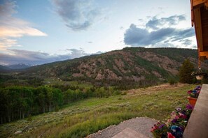 A mountainous landscape with a view of a building with a balcony.