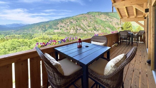 A wooden deck with a table and chairs, overlooking a mountainous landscape. - Chalet Homestake View between Vail and Leadville (Red Cliff)