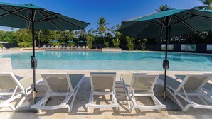 Ein Schwimmbecken mit Liegestühlen und Sonnenschirmen.
