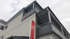 Um edifício moderno com uma placa vermelha que diz "THIRSCHEN TREFFPUNKT".