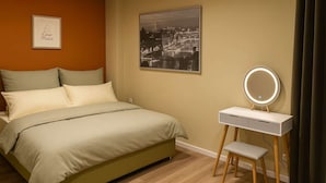 A bedroom with a bed, a bedside table with a mirror, a framed picture on the wall, and a cityscape poster. - Casa Mateo - Mediterranean vacation apartment in Bielefeld (Bielefeld)