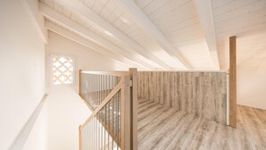A spacious attic room with a wooden staircase and a view of the sky through a window. - Locanda L'orangerie (Crespellano)