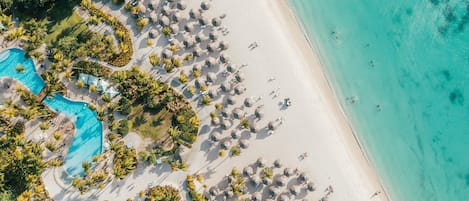 Sulla spiaggia, sabbia bianca, cabine (a pagamento), lettini da mare