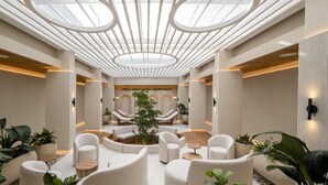 A modern interior with a central seating area, recessed lighting, and a skylight.