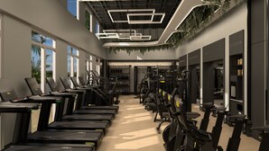 A modern gym with treadmills, elliptical machines, and weight equipment.