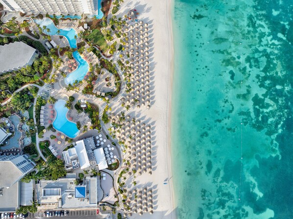A resort with a pool, beach, and multiple buildings.
