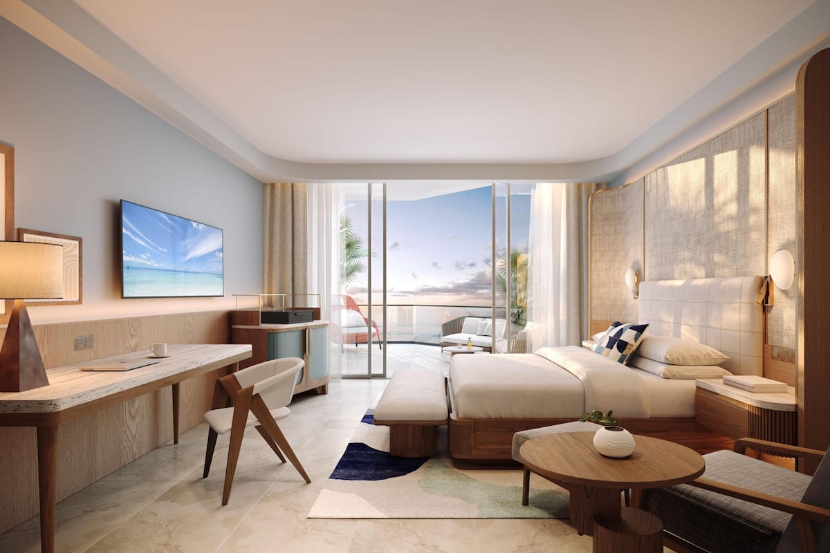 Ein modernes Hotelzimmer mit einem großen Bett, einem Schreibtisch, einem Sofa und einem Balkon mit Blick.