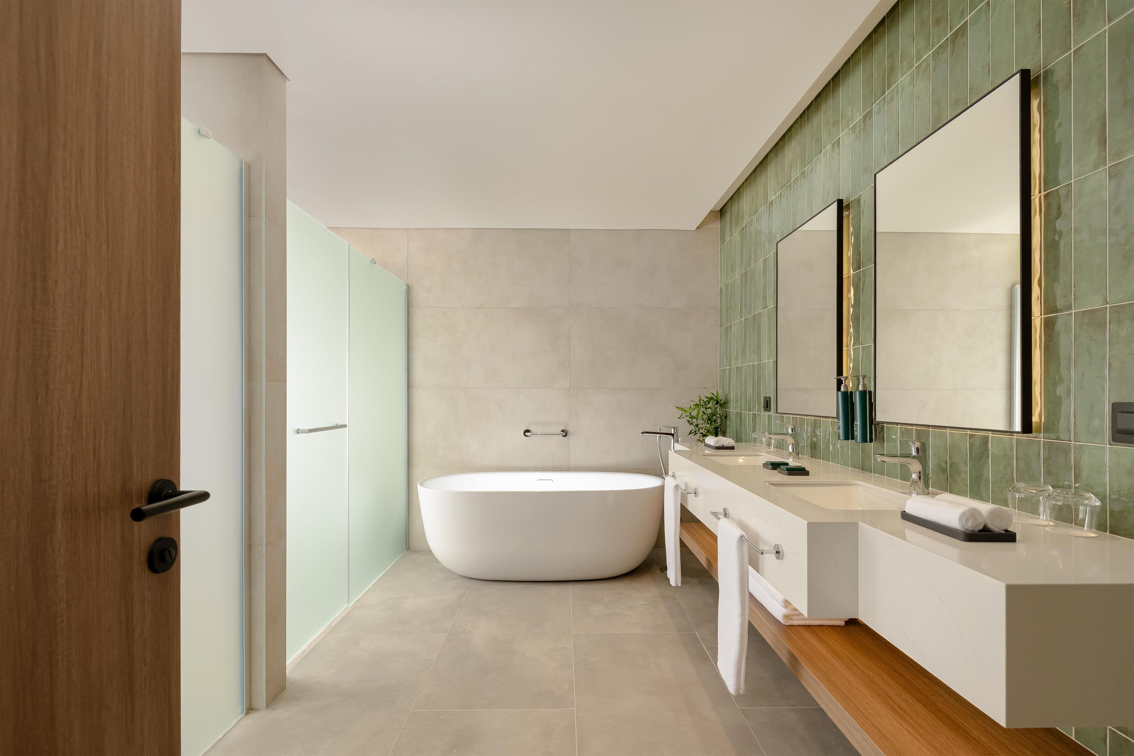 Une salle de bain moderne avec une baignoire sur pieds, un grand miroir et un meuble-lavabo.