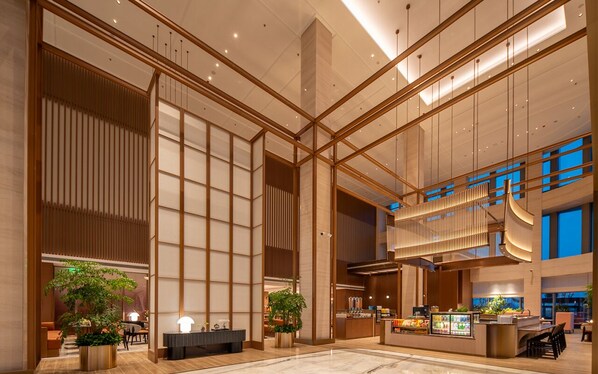 A spacious lobby with a reception desk, seating area, and large windows. - Hilton Garden Inn Wuhu Economic Tech Zone (Wuhu)