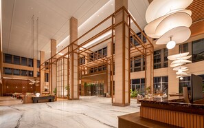 A spacious lobby with a marble floor, wooden reception desk, and modern lighting fixtures. - Hilton Garden Inn Wuhu Economic Tech Zone (Wuhu)