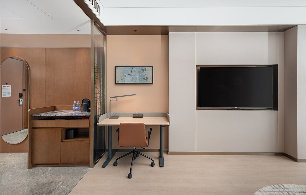 A modern office space with a desk, chair, and a large monitor.