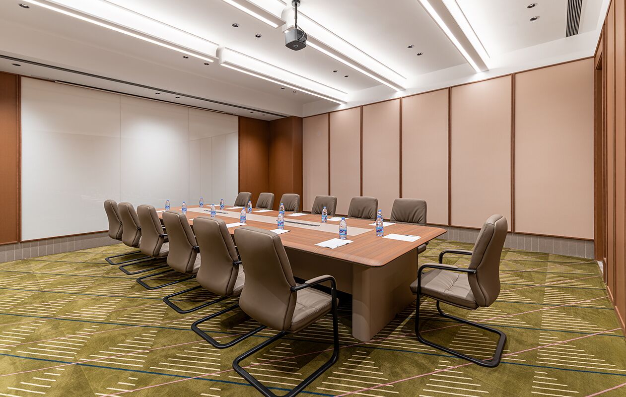 A conference room with a long table, multiple chairs, and water bottles.