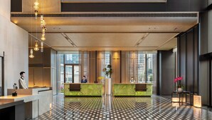 A hotel lobby with a check-in counter, a reception desk, and a patterned floor. - Doubletree By Hilton Zigong (Zigong)