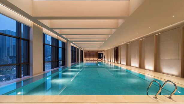 A modern indoor swimming pool with a long view corridor, large windows, and a skylight. - Doubletree By Hilton Zigong (Zigong)