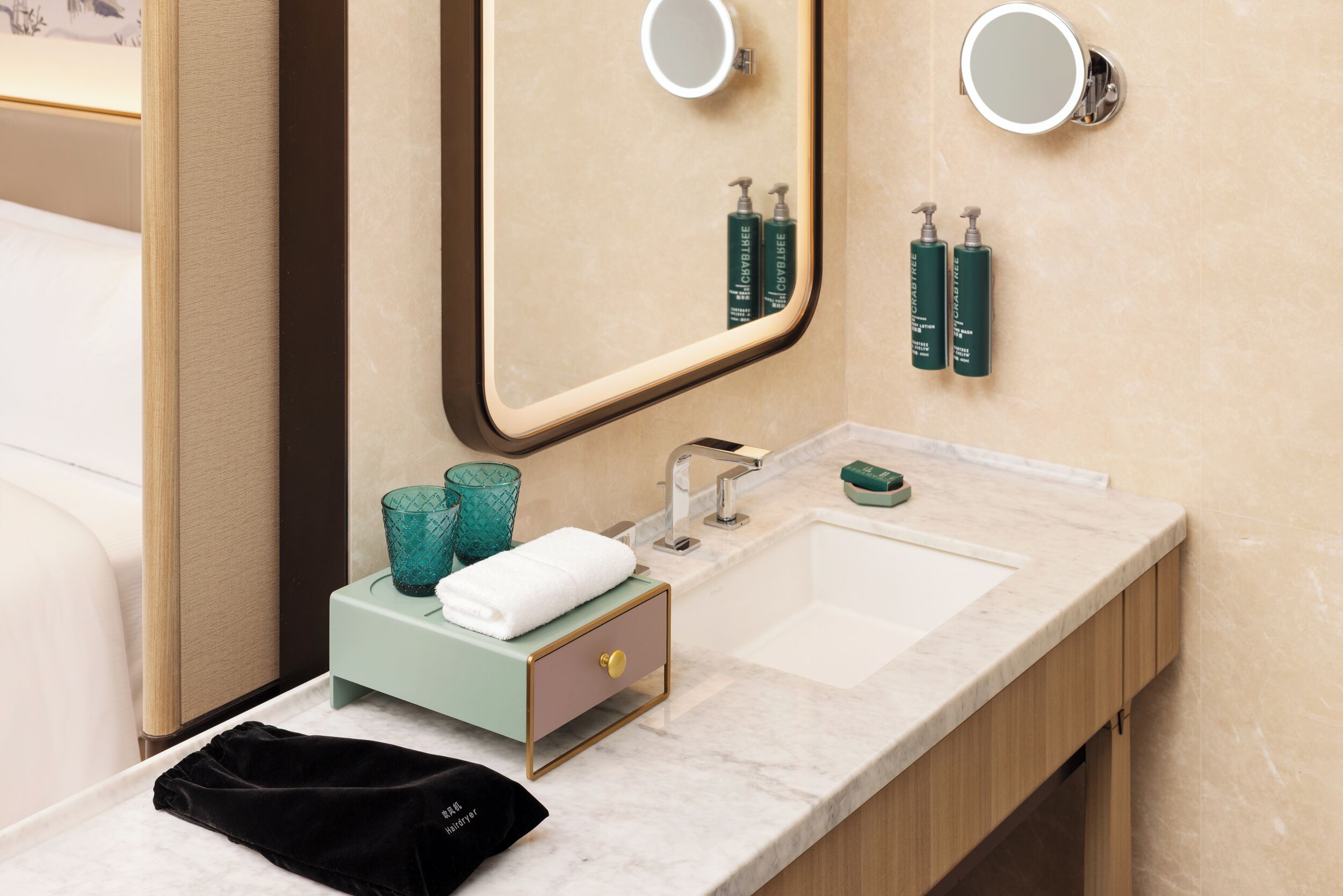 A bathroom with a large mirror, two wall-mounted mirrors, a sink, and toiletries.