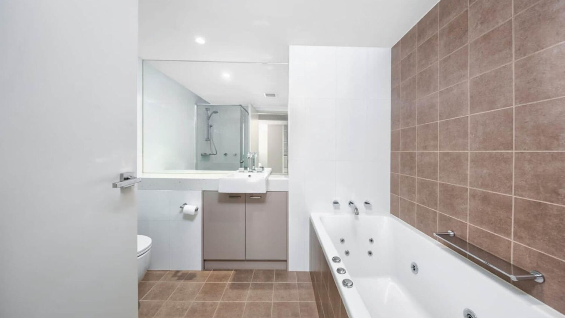 A modern bathroom with a bathtub, a toilet, and a sink.