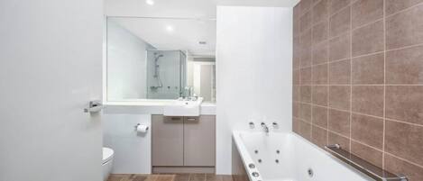 A modern bathroom with a bathtub, a toilet, and a sink.