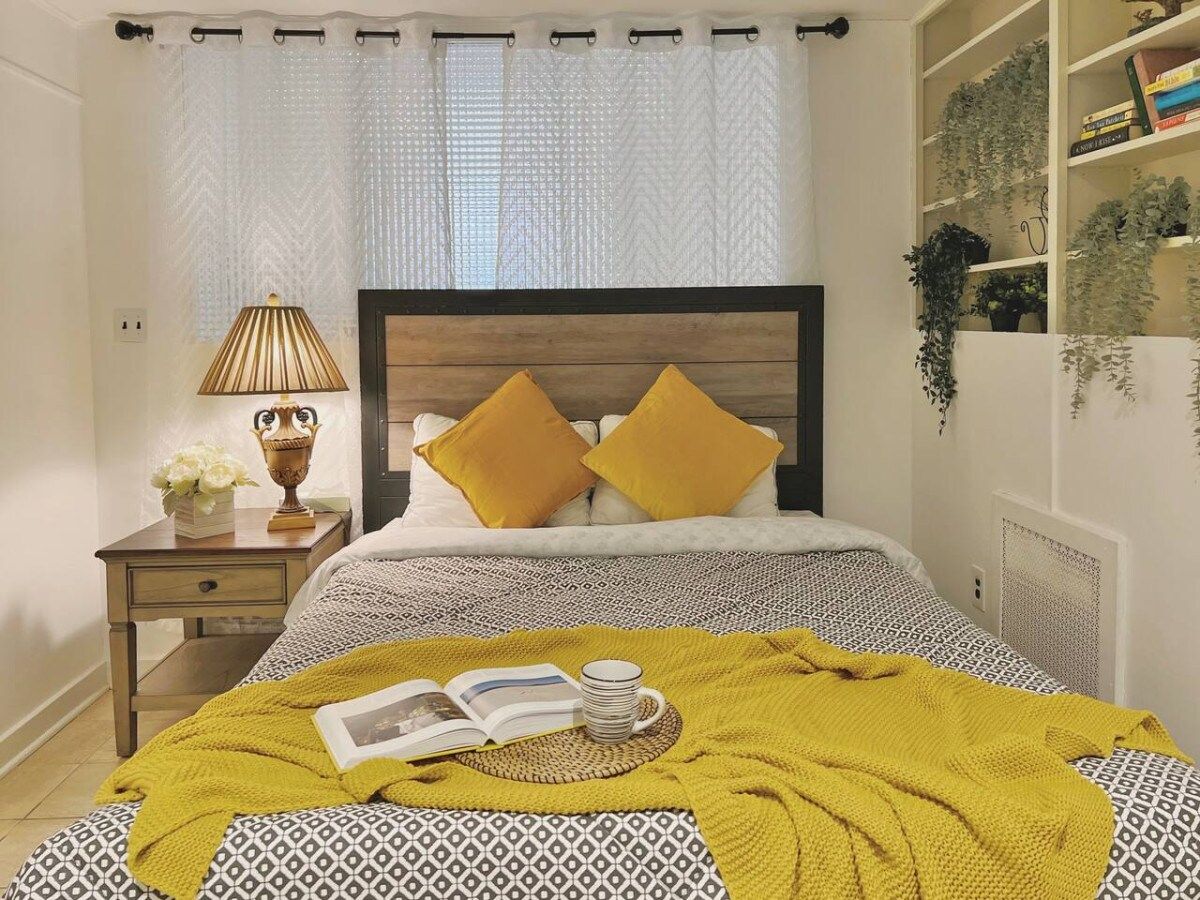 Ein Schlafzimmer mit einem Bett, einem Nachttisch, einer Lampe und einem Bücherregal.