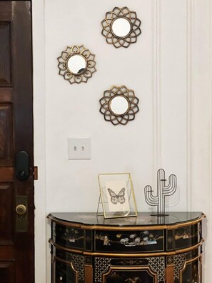A wall with three decorative mirrors and a cactus ornament.