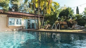 A swimming pool with a house in the background, surrounded by palm trees and a clear sky. - Luxury Villa w/ Pool, Mountain Views near NASA (Altadena)