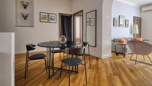Un moderno comedor con una mesa redonda y cuatro sillas, un sofá y una lámpara en un espacio habitable.
