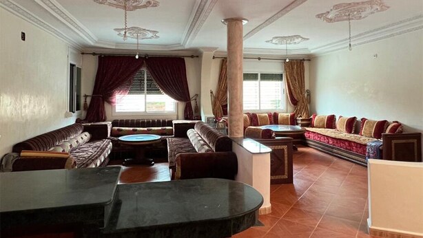 A spacious living room with a sofa set, a coffee table, and a marble accent piece. - Spacious Villa near the Beach (Saidia)