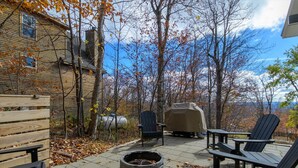 A patio with Adirondack chairs, a fire pit, and a covered grill area. - Mountain side, remodeled  4 br neat trail head. (Wilmington)