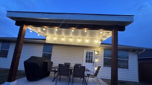 A covered patio with string lights, a grill, and outdoor furniture. - Tremendous space with covered patio in central McKinney (McKinney)