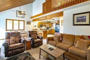 A cozy living room with leather chairs, a sofa, and a coffee table.