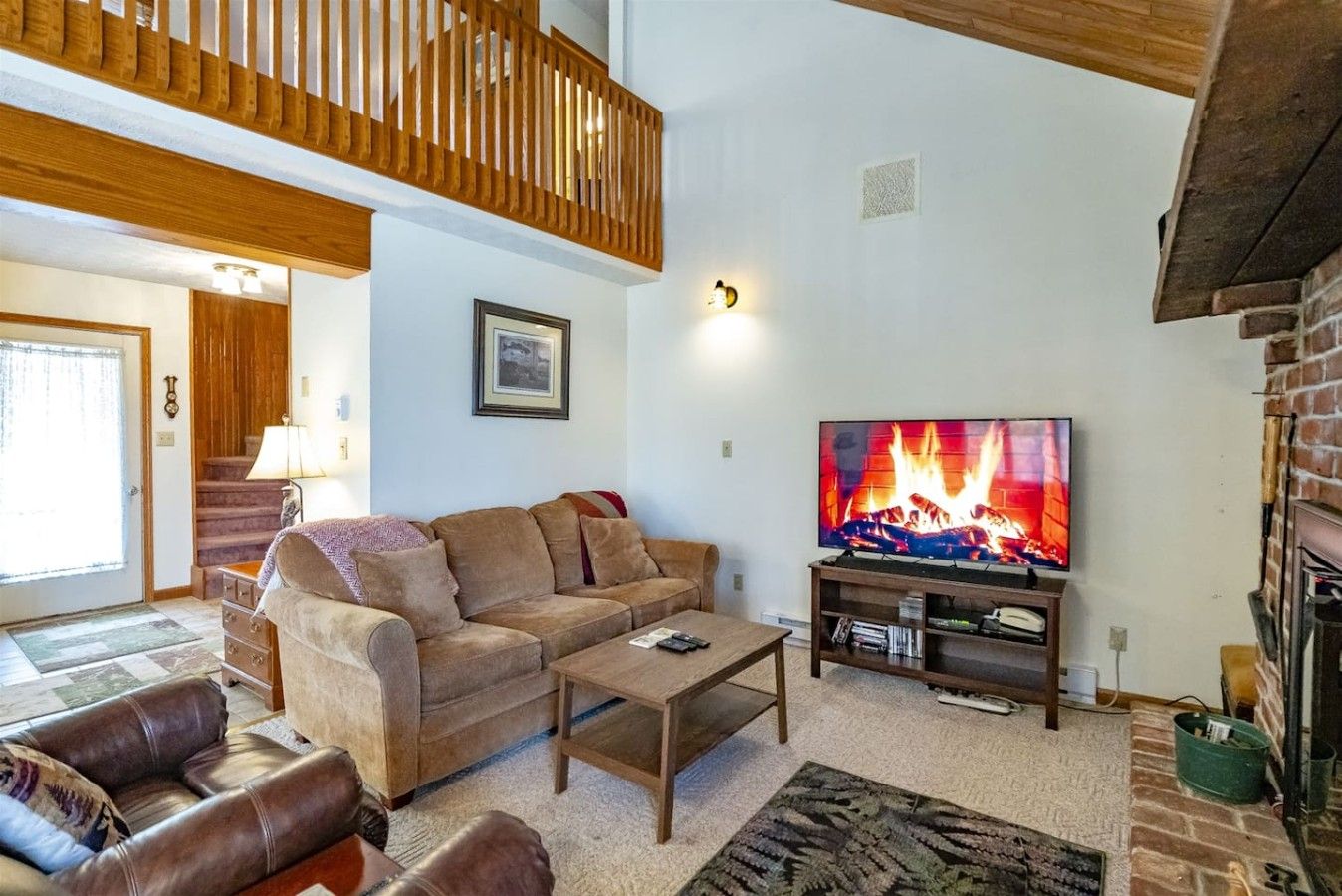 A cozy living room with a fireplace, a television, and a comfortable sofa.