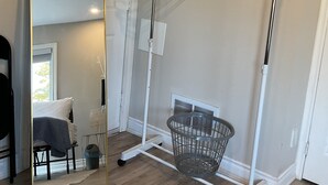 A room with a large mirror, a clothes rack, and a basket. - Cozy, peaceful family-friendly neighborhood-steps away from the credit river (Mississauga)