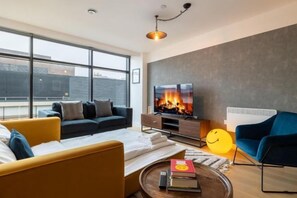 Een moderne woonkamer met een bank, een salontafel en een televisie.