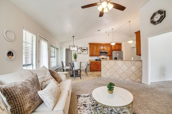 A spacious living room with a white sofa, a coffee table, and a ceiling fan. - Fenced-In Yard: Home < 1 Mi to Lake Ray Hubbard! (Garland)