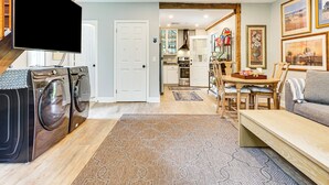 A laundry area with a washing machine and dryer, a dining area with a table and chairs, and a living area with a sofa and a TV. - Pet-Friendly Cottage, 2 Mi to Saugatuck Falls (Redding)
