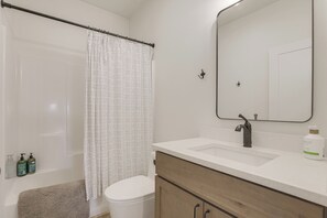 A bathroom with a shower curtain, toilet, sink, and mirror. - Mtn-Views, Pet-Friendly! Family Home in Ranchester (Ranchester)