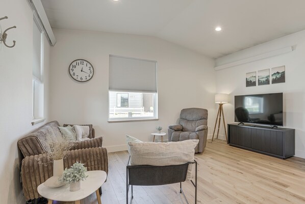 A modern living room with a sofa, armchair, coffee table, and a TV. - Mtn-Views, Pet-Friendly! Family Home in Ranchester (Ranchester)