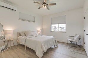 A bedroom with a bed, bedside lamps, a ceiling fan, a window, and a chair. - Mtn-Views, Pet-Friendly! Family Home in Ranchester (Ranchester)