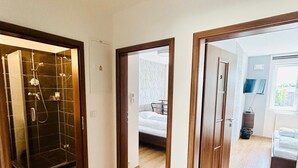 Una habitación de hotel con ducha, cama y vistas al exterior.
