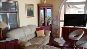A living room with a beige sofa, a small round table, a TV, and a cabinet. - Apartments Jaman Dalmatica Čiovo (Okrug)