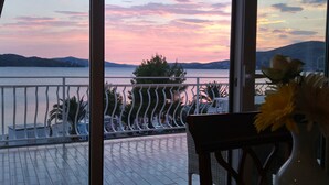 A balcony with a view of a lake and mountains during sunset. - Apartments Jaman Dalmatica Čiovo (Okrug)